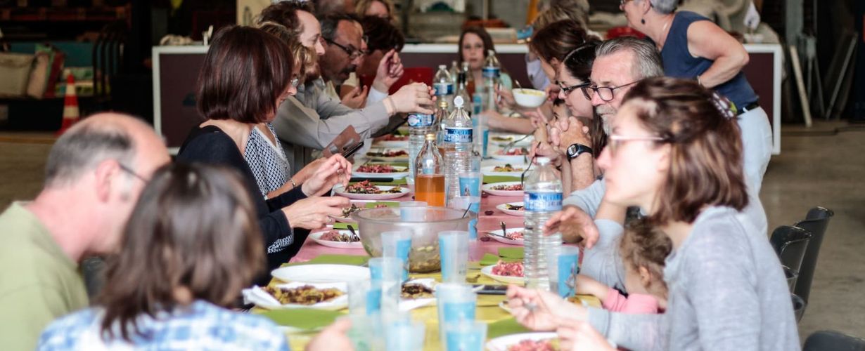 grande tablée avec des personnes en train de manger