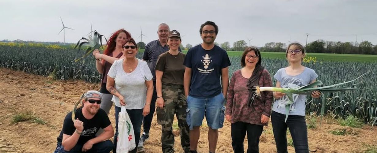 groupe de personnes dans un champs de poireaux, membres de l'association Robin.e.s des Bennes